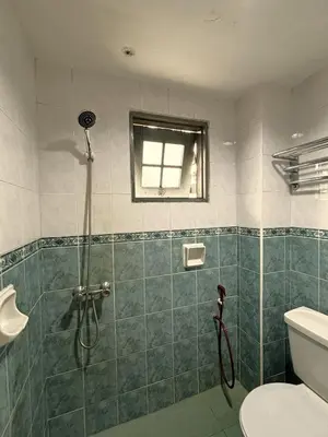 a bathroom with a shower with a toilet and a window at Cool Point Hotel in Tanah Rata