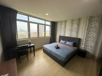 a bedroom with a bed and a desk and a window at 2BR, 1 Car Park, 4Pax Seaview 118IslandPlaza in Tanjong Tokong