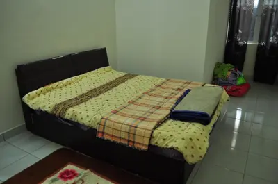 a bed in a bedroom with a blanket on it at Uwais Homestay Segari Lumut in Lumut