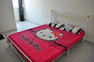 a bed with a hello kitty blanket on it at Uwais Homestay Segari Lumut in Lumut