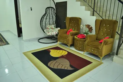 a living room with two chairs and a rug at Uwais Homestay Segari Lumut in Lumut