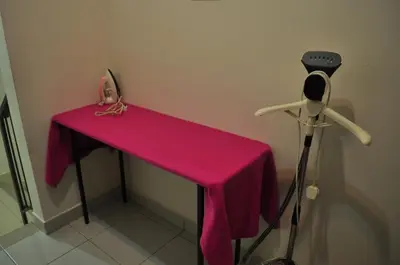 a table with a pink table cloth and a camera at Uwais Homestay Segari Lumut in Lumut