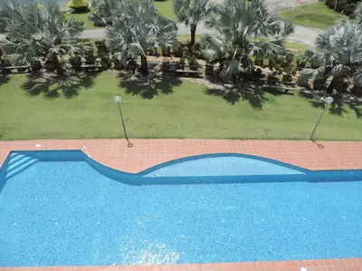 an overhead view of a blue swimming pool with palm trees at Marina Island Seaview Homestay in Lumut