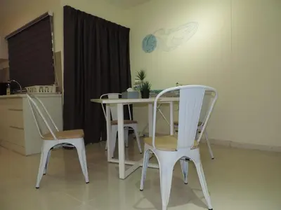 a table and chairs in a kitchen with a clock on the wall at Marina Island Seaview Homestay in Lumut