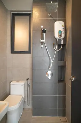 a bathroom with a toilet and a sink and a mirror at Urban Suite By Bold@Seaview in Jelutong