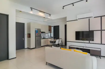 a living room with a couch and a kitchen at Urban Suite By Bold@Seaview in Jelutong