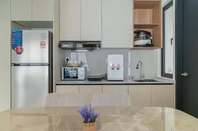 a kitchen with a refrigerator and a table with chairs at Urban Suite By Bold@Seaview in Jelutong