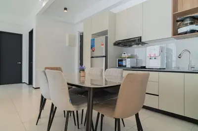 a kitchen with a dining table and white chairs at Urban Suite By Bold@Seaview in Jelutong