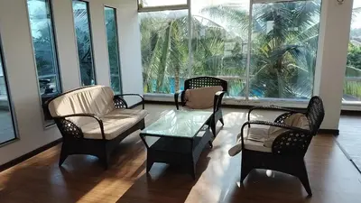 a living room with chairs and a table and a glass table at Idea Homestay 2 in Ipoh