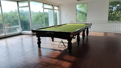 a pool table in a room with windows at Idea Homestay 2 in Ipoh