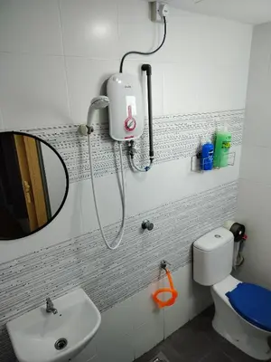 a bathroom with a sink and a mirror and a toilet at Idea Homestay 2 in Ipoh