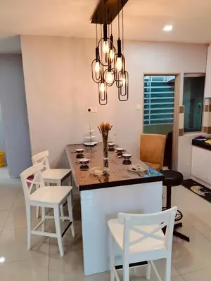 a kitchen with a island with white chairs and a chandelier at Idea Homestay 3 in Chemor