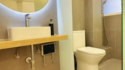 a bathroom with a toilet and a sink and a mirror at Noordin ClanJetties Komtar Heritage Studio - E in George Town