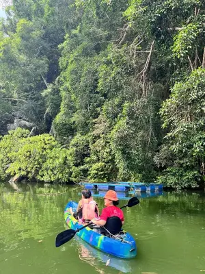 a man and a child in a canoe on a river at KT’s Lake House in Ipoh