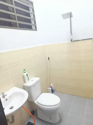 a bathroom with a white toilet and a sink at KT’s Lake House in Ipoh