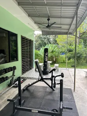 a room with a gym with a bench and a fan at KT’s Lake House in Ipoh
