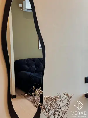 a mirror in a living room with a black couch at Ipoh Town Anderson Suites 4-6 pax by Verve in Ipoh