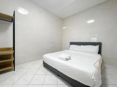 a bedroom with a white bed with a towel on it at Taman Saikat IPOH Happy Suites by Verve(12 pax) in Ipoh