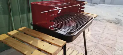 a grill and a wooden bench next to a chair at Taman Saikat IPOH Happy Suites by Verve(12 pax) in Ipoh
