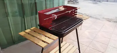 a barbecue grill sitting on a bench next to a building at Taman Saikat IPOH Happy Suites by Verve(12 pax) in Ipoh
