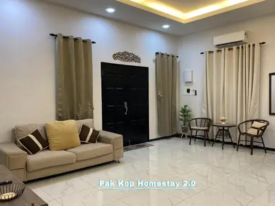 a living room with a couch and a table at ISLAMIC Pak Kop Homestay with private pool 2 in Parit Buntar