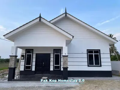 a white house with a black door at ISLAMIC Pak Kop Homestay with private pool 2 in Parit Buntar