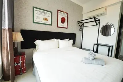 a bedroom with a large white bed with a towel on it at SIDE CONTRUCTION MODERN DESIGN@THE MAJESTIC IPOH in Ipoh