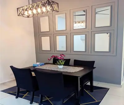 a dining room with a table and chairs and a chandelier at IZZ Homestay MUSLiiM in Ipoh