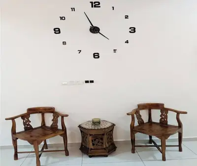 two chairs and a clock on a wall at IZZ Homestay MUSLiiM in Ipoh