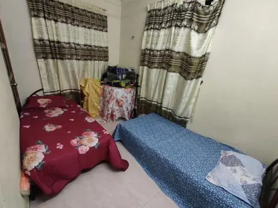 a room with a bed and a table with curtains at Penang Green Homestay 1st Floor in Permatang Pauh
