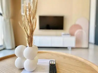 a vase sitting on a table next to a remote control at Urban Suites #Creamy style #Infinity Pool #local neighbourhood #5pax #3BR 2bath #2Queen 1Single #Quality well maintained #Private host in Jelutong