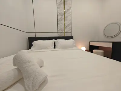 a bedroom with a white bed with white sheets and pillows at Modern Elegance - Urban Suites by Ocean Luxe in Jelutong