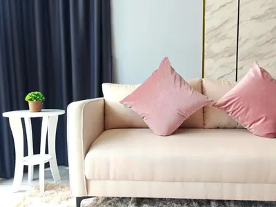 a couch with two pillows on it in a living room at Modern Elegance - Urban Suites by Ocean Luxe in Jelutong