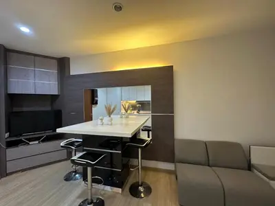 a kitchen and living room with a table and a couch at Luxury Suites 118 Island Plaza in Tanjong Tokong