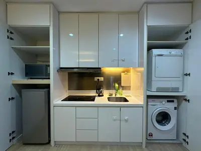 a kitchen with white cabinets and a sink and a microwave at Luxury Suites 118 Island Plaza in Tanjong Tokong