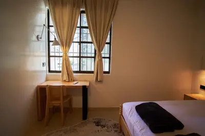 a bedroom with a bed and a desk and a window at Some Place Else in George Town