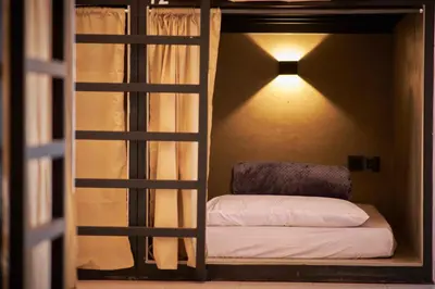 a room with a bunk bed with a light on the wall at Some Place Else in George Town