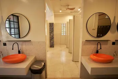 a bathroom with two orange sinks and two mirrors at Some Place Else in George Town