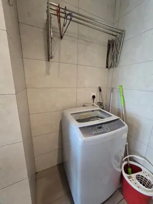 a washing machine in a corner of a room at The Octagon Premium Suite - Ipoh in Ipoh