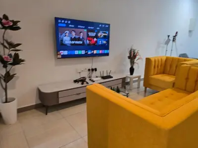 a living room with a couch and a tv on the wall at The Octagon Premium Suite - Ipoh in Ipoh