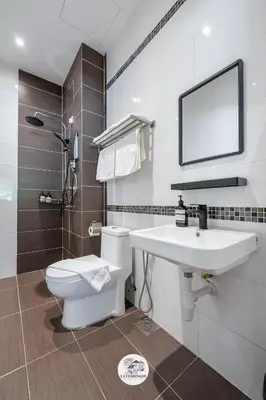a bathroom with a sink and a toilet and a mirror at La Ferringhi Villa in Batu Ferringhi