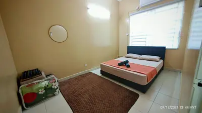 a bedroom with a bed with a mirror and a window at Homestay Qasrina Semi D 4 Bilik in Kepala Batas