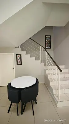 a room with a table and a staircase at Homestay Qasrina Semi D 4 Bilik in Kepala Batas
