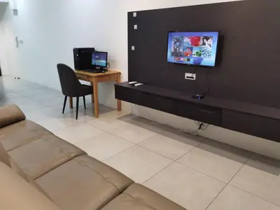 a living room with a couch and a tv on a wall at Meritus Premium Home Suite 8 Pax in Perai