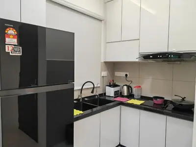 a kitchen with white cabinets and a black refrigerator at Meritus Premium Home Suite 8 Pax in Perai