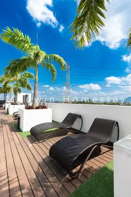 a deck with two chairs and a palm tree at Meritus Premium Home Suite 8 Pax in Perai