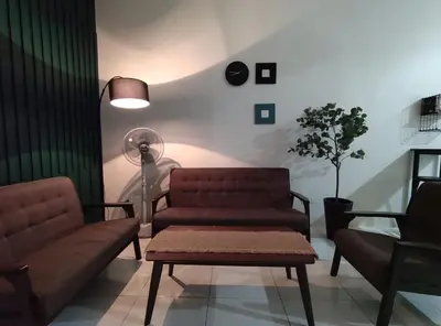 a living room with a couch and a table and a fan at 32 Impian Homestay, Taiping in Taiping