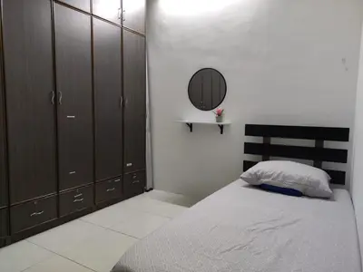 a bedroom with a bed with a mirror and cabinets at 32 Impian Homestay, Taiping in Taiping