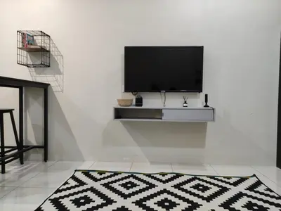 a living room with a flat screen tv on a white wall at 32 Impian Homestay, Taiping in Taiping