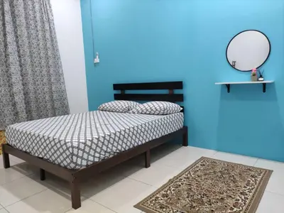 a bedroom with a bed with a mirror and a blue wall at 32 Impian Homestay, Taiping in Taiping